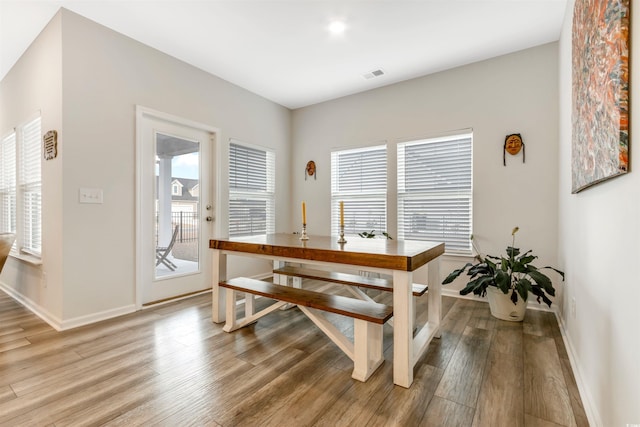 dining room featuring visible vents, light wood-style flooring, and baseboards