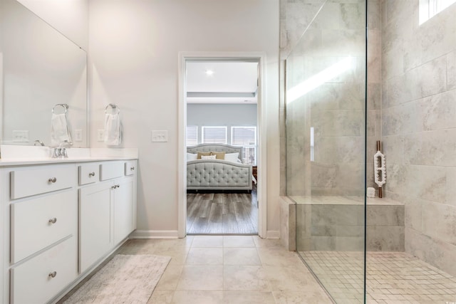 ensuite bathroom with vanity, baseboards, ensuite bathroom, walk in shower, and tile patterned floors