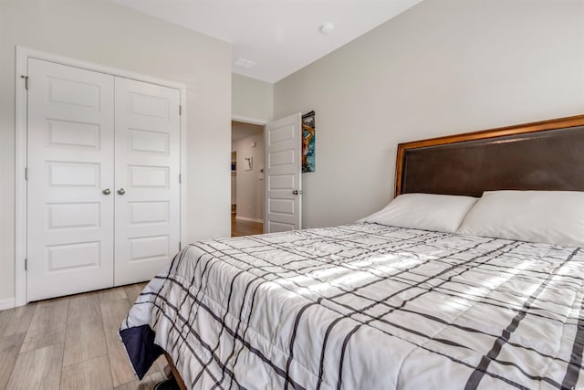 bedroom with a closet, baseboards, and light wood-style floors