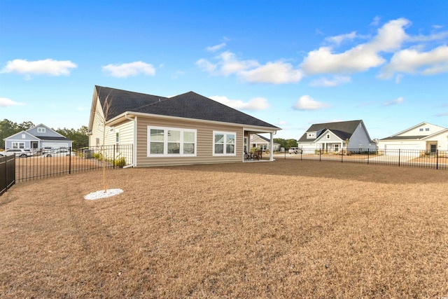 rear view of property featuring a patio area, a lawn, and a fenced backyard