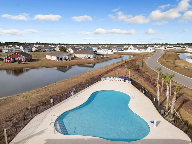 pool featuring a residential view, a fenced backyard, and a water view