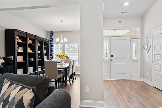 foyer with an inviting chandelier and light wood-type flooring