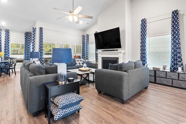 living room with hardwood / wood-style flooring, high vaulted ceiling, and ceiling fan