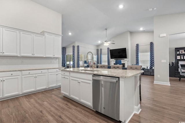 kitchen with ceiling fan, sink, dishwasher, white cabinetry, and an island with sink