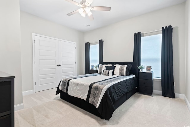 carpeted bedroom with ceiling fan and a closet