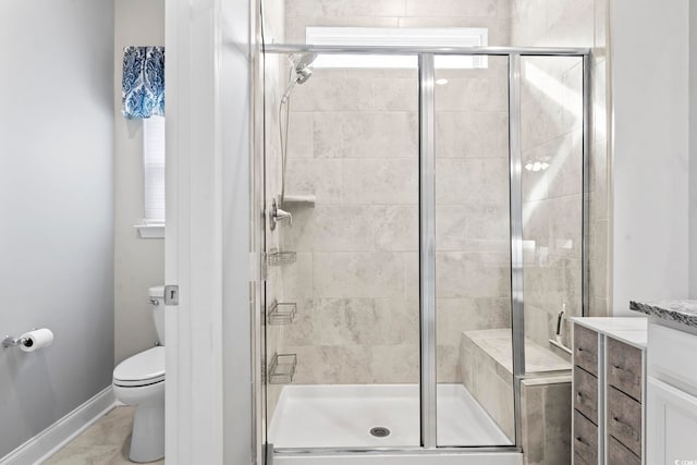 bathroom with tile patterned flooring, a shower with door, vanity, and toilet