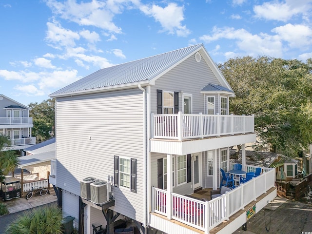 back of property with a balcony and central air condition unit