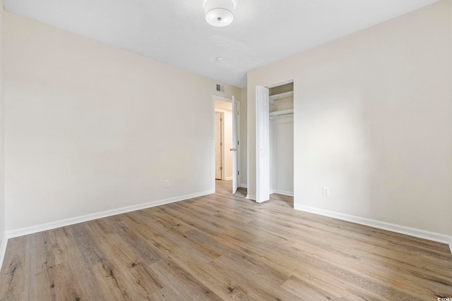 unfurnished bedroom with light hardwood / wood-style floors and a closet