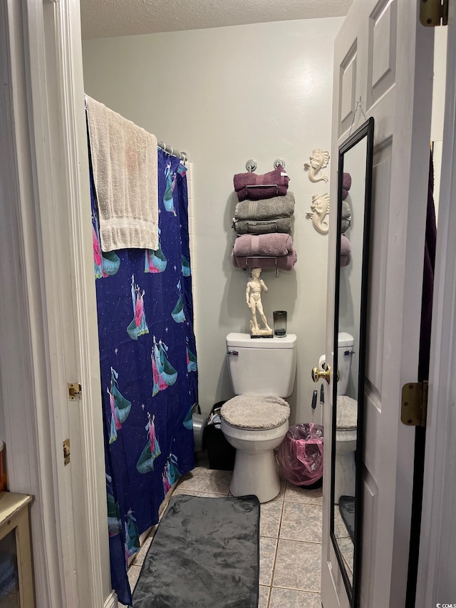 bathroom featuring tile patterned floors, a textured ceiling, and toilet