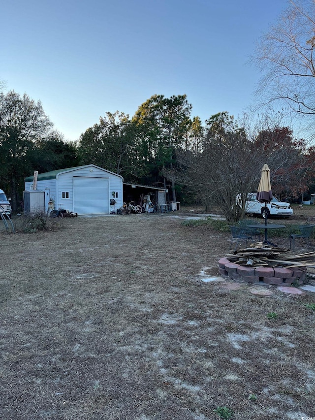 view of yard with a garage and an outbuilding