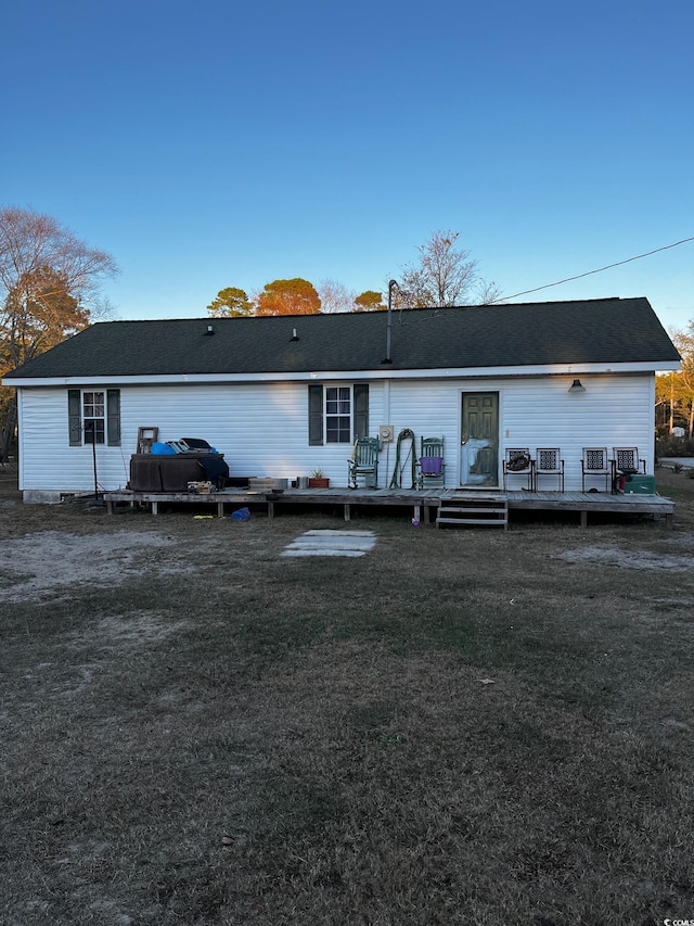 back of house with a wooden deck and a lawn