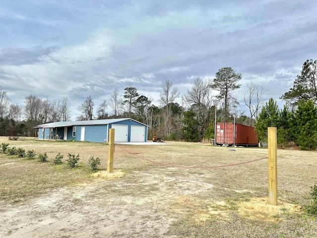 view of yard featuring a garage and an outdoor structure