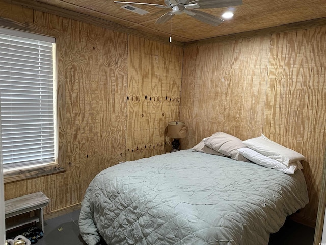 bedroom featuring ceiling fan, wooden walls, and wooden ceiling