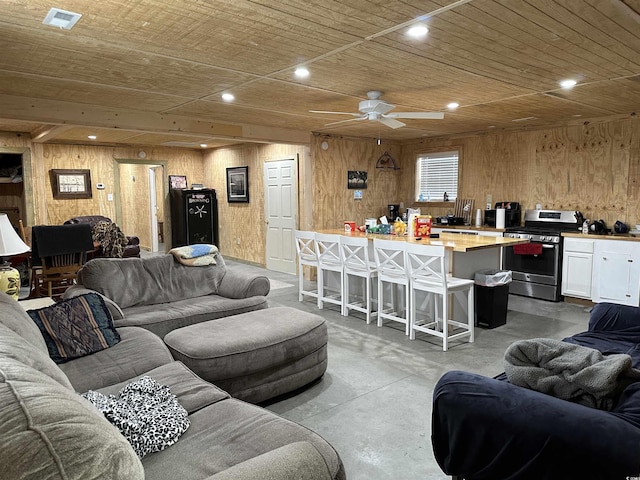 living room with wood ceiling, wooden walls, and ceiling fan