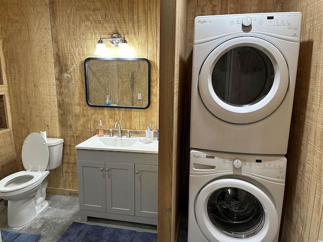 washroom with stacked washer and dryer and sink