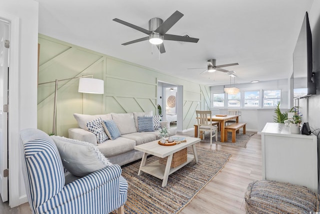 living room featuring light wood-type flooring and ceiling fan