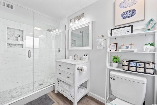 bathroom featuring toilet, vanity, hardwood / wood-style floors, and walk in shower