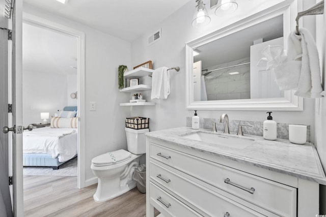 bathroom featuring curtained shower, hardwood / wood-style floors, vanity, and toilet