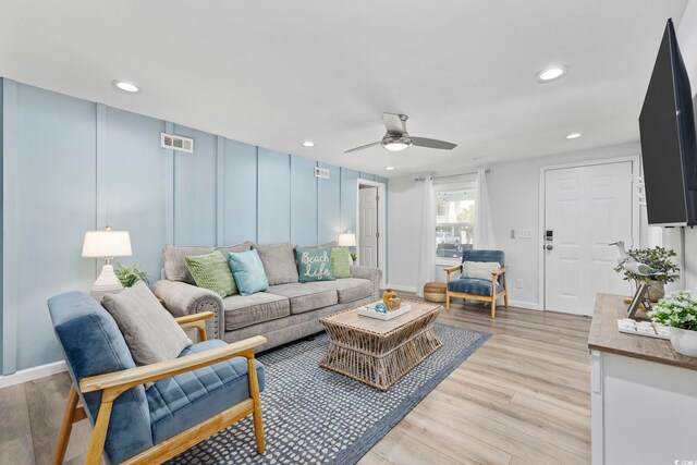 living room with light wood-type flooring and ceiling fan