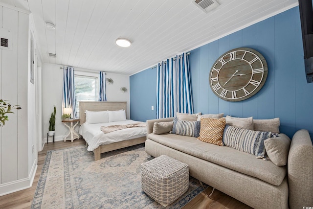 bedroom with ornamental molding, wood ceiling, and hardwood / wood-style floors