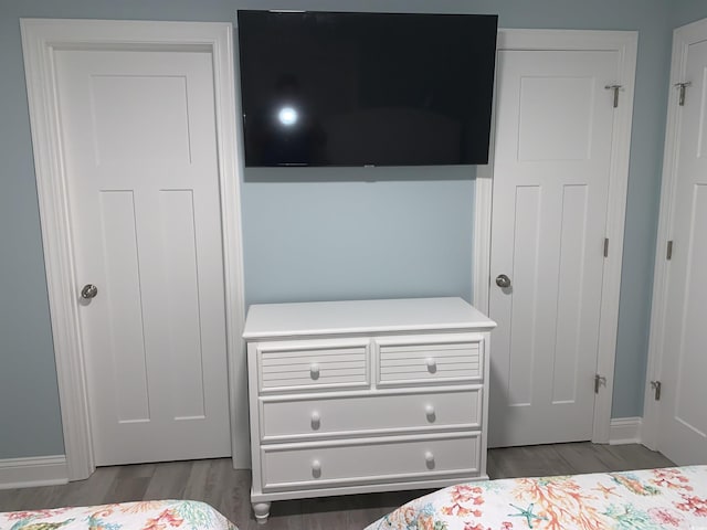 bedroom featuring baseboards and wood finished floors