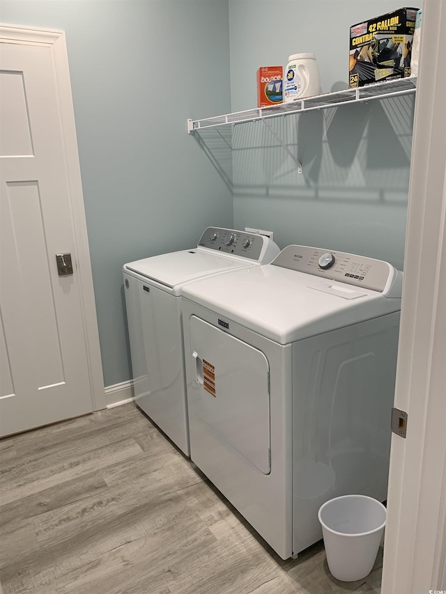 laundry room featuring washing machine and dryer, light wood-style floors, and laundry area