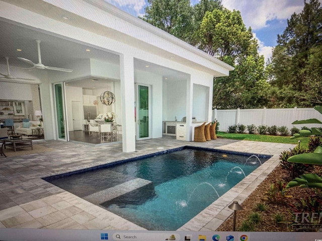 view of pool with a fenced in pool, a patio, an outdoor kitchen, a ceiling fan, and fence