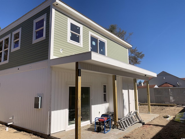 rear view of property featuring fence