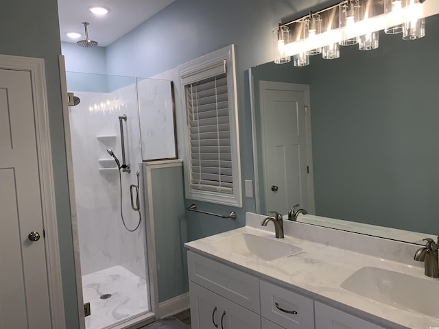 bathroom with double vanity, a stall shower, a notable chandelier, and a sink