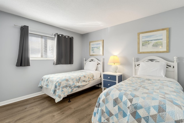 bedroom with a textured ceiling and dark wood-type flooring