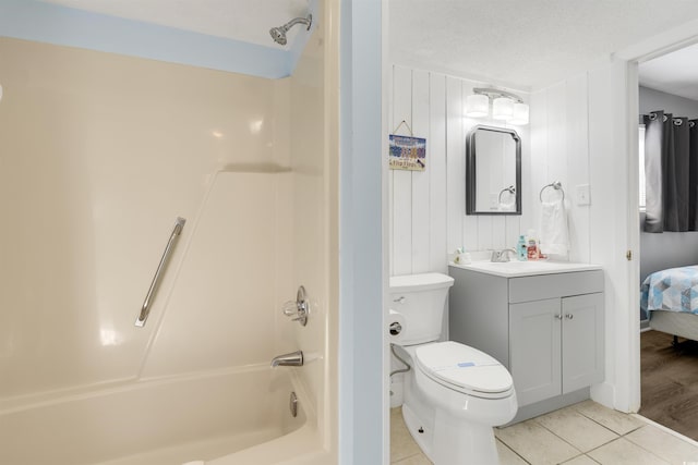 full bathroom featuring tile patterned floors, vanity, a textured ceiling,  shower combination, and wood walls