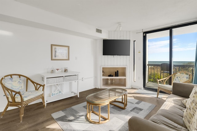 living room featuring plenty of natural light, expansive windows, and dark wood-type flooring