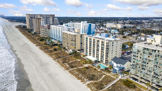 drone / aerial view featuring a water view and a beach view