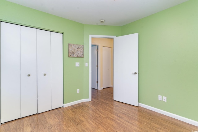 unfurnished bedroom with light hardwood / wood-style flooring and a closet