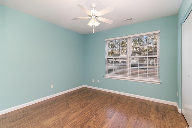 spare room with ceiling fan and dark wood-type flooring