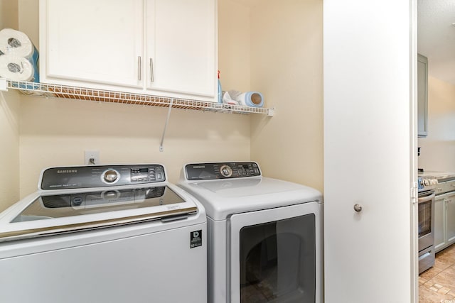 laundry room with washer and clothes dryer and cabinets