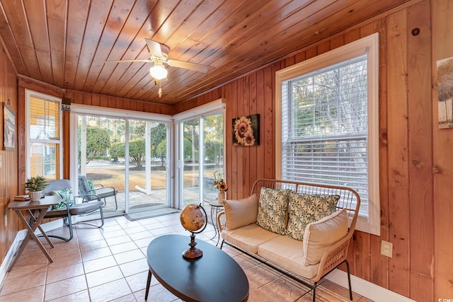 interior space featuring wooden walls, light tile patterned flooring, wooden ceiling, and ceiling fan