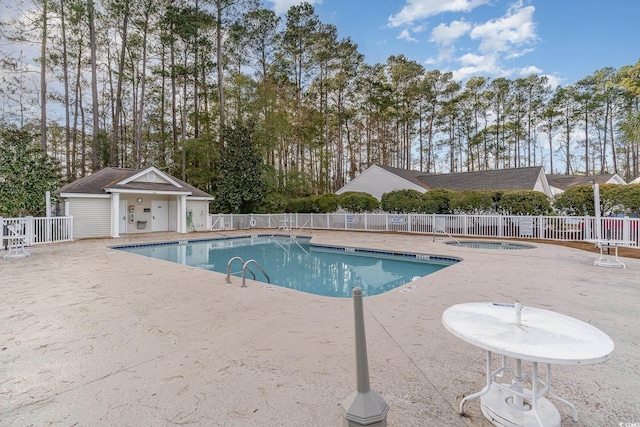 view of swimming pool with a patio area and a hot tub