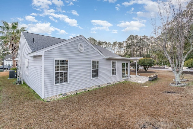 view of side of property with a patio area, a yard, and central AC unit