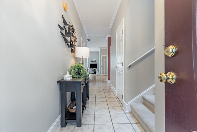 hall featuring ornamental molding and light tile patterned floors