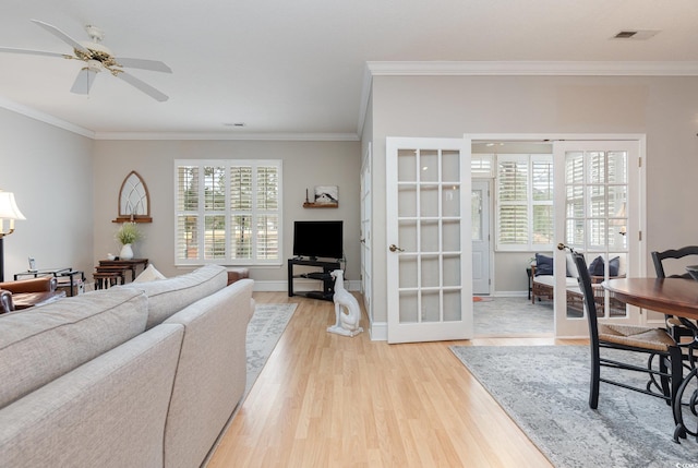 living room featuring ceiling fan, light hardwood / wood-style floors, ornamental molding, and french doors