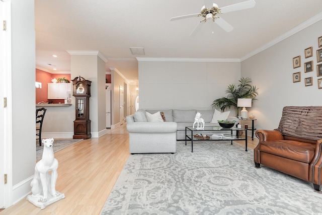 living room featuring ceiling fan, wood-type flooring, and crown molding