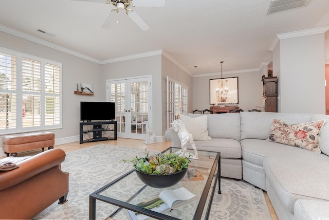 living room featuring crown molding, light hardwood / wood-style floors, and ceiling fan with notable chandelier