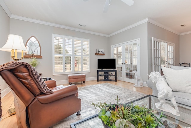 living room with ceiling fan, french doors, ornamental molding, and light wood-type flooring