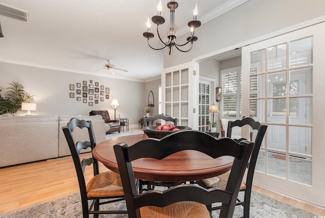 dining room featuring ceiling fan with notable chandelier, light wood-type flooring, and ornamental molding