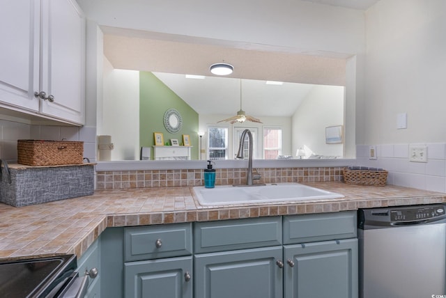 kitchen with appliances with stainless steel finishes, tasteful backsplash, ceiling fan, sink, and lofted ceiling