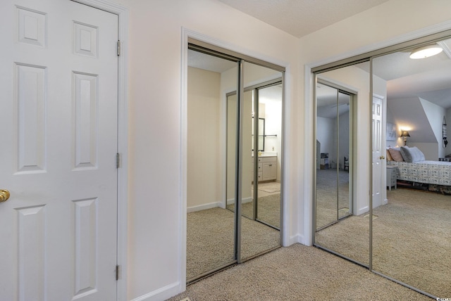 bedroom featuring carpet and multiple closets