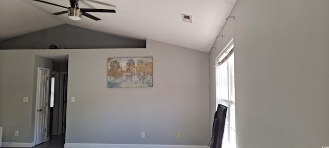 empty room featuring baseboards, visible vents, vaulted ceiling, and a ceiling fan