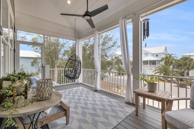 sunroom / solarium with ceiling fan and vaulted ceiling