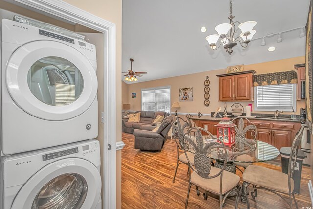 6001-1909 S Kings Hwy, Myrtle Beach, SC 29575 - clothes washing area with wood finished floors, laundry area, a sink, stacked washer and clothes dryer, and ceiling fan with notable chandelier